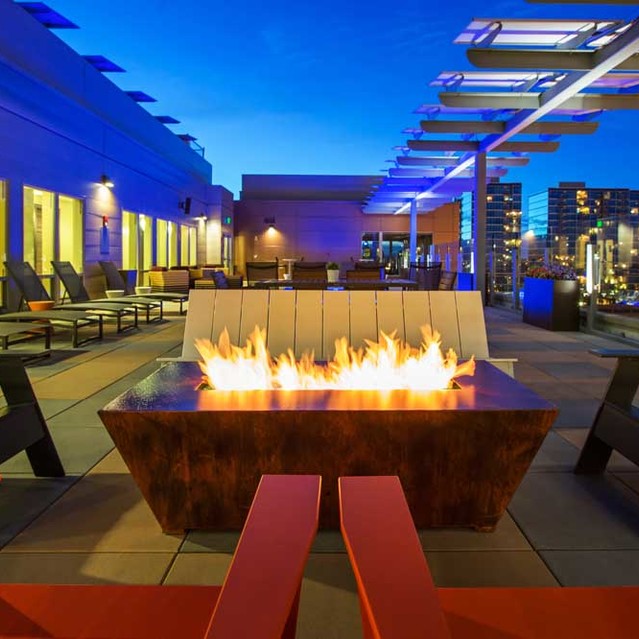 Cadence Union Station Apartments - Rooftop Fire Pit with Seating and City Skyline View at Night 