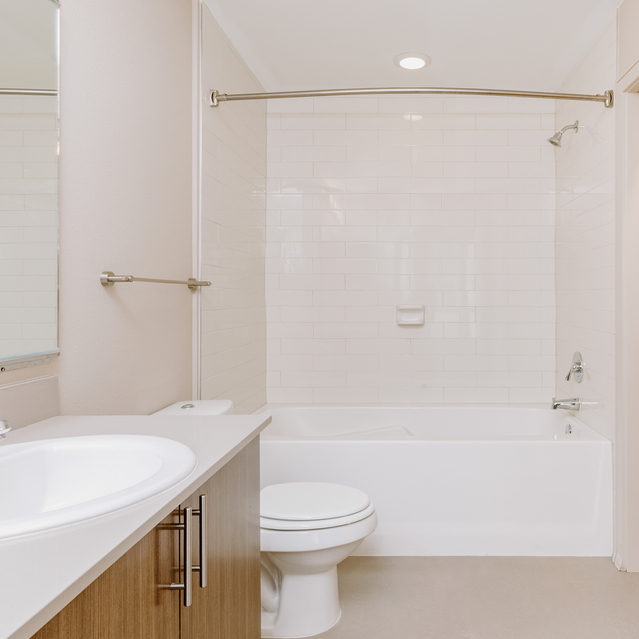 Cadence Union Station Apartments - Modern Bathroom with White Sink, Toilet, Bathtub, and Open Closet