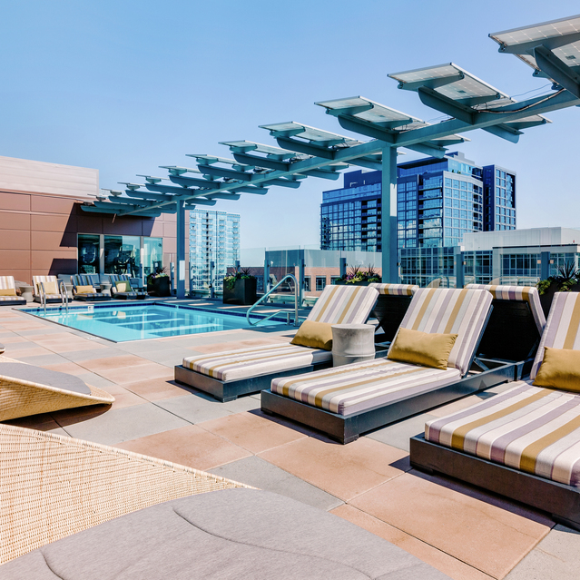 Cadence Union Station Apartments - Rooftop Pool with Lounge Chairs and City Skyline View 
