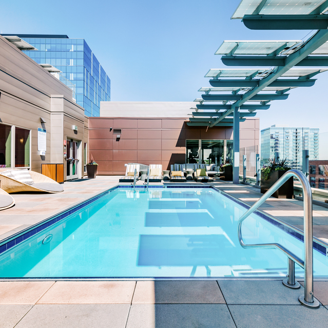 Cadence Union Station Apartments - Rooftop Pool with Lounge Chairs and Modern Urban Architecture 