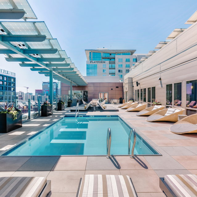 Cadence Union Station Apartments - Rooftop Pool with Lounge Chairs and Modern Urban Architecture 
