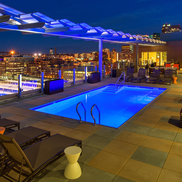 Cadence Union Station Apartments – Rooftop Pool at Night with Lounge Chairs and City Skyline View